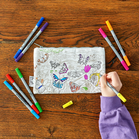 child in purple jumper colouring in pencil case