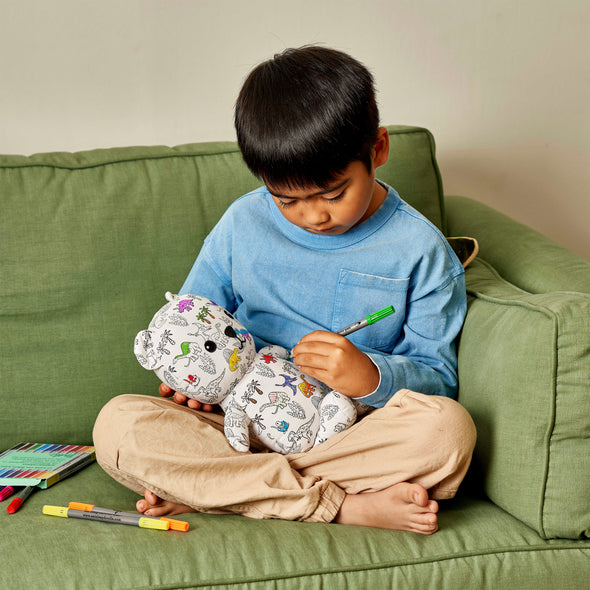 boy sat on sofa colouring in an artie bear 