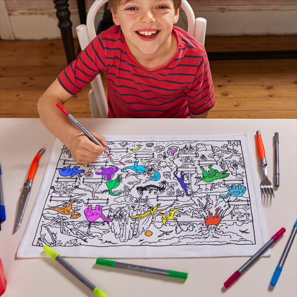 boy in red shirt looking up whilst colouring